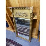AN ANTIQUE GILT FRAMED PIER MIRROR WITH MOULDED GESSO PANEL.