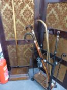 VARIOUS WALKING STICKS, A STICK STAND, AND A EWBANK FLOOR SWEEPER.