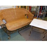 A WROUGHT IRON AND RATTAN CONSERVATORY TWO SEAT SETTEE AND MATCHING COFFEE TABLE.