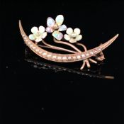 AN EDWARDIAN 9ct GOLD SEED PEARL AND ENAMEL CRESCENT BROOCH ADORNED WITH A SPRAY OF FLOWERS WITH