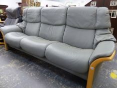 AN EKORNES STRESSLESS THREE SEAT SOFT GREY LEATHER RECLINING SETTEE WITH WOODED ACCENTS.