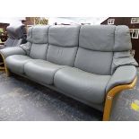 AN EKORNES STRESSLESS THREE SEAT SOFT GREY LEATHER RECLINING SETTEE WITH WOODED ACCENTS.