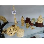 A LARGE ANTIQUE IVORY PUZZLE BALL, A CARVED BOARS TUSK BRIDGE, VARIOUS ORNAMENTS, ETC.