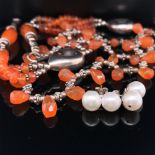 A SILVER AND ORANGE HARDSTONE GRADUATED AND WOVEN REVIVALIST STYLE NECKLACE APPROX LENGTH 41cms,