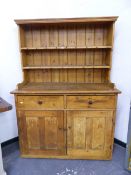 AN ANTIQUE PINE KITCHEN DRESSER. W 125 X D 55 X H 175cms.