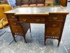 A GOOD QUALITY LATE VICTORIAN BREAKFRONT MAHOGANY WRITING DESK, 3/4 BRASS GALLERY BANKS OF DRAWERS.