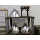 THREE ALUMINIUM INDUSTRIAL LIGHT SHADES, AND AN ALUMINIUM STAND. SHADES APPROX DIAMETER 54cms DROP