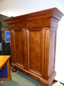 A LARGE CONTINENTAL WALNUT TWO DOOR ARMOIRE.