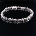 A SILVER RUBOVER SET LINE BRACELET WITH BLUE AND WHITE CUBIC ZIRCONIAS, COMPLETE WITH TWO FIGURE
