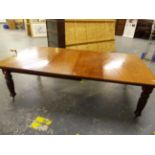 A LATE VICTORIAN MAHOGANY WIND OUT EXTENDING DINING TABLE ON TURNED REEDED LEGS, COMPLETE WITH TWO