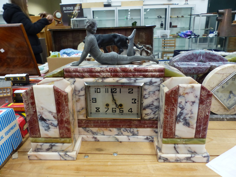AN ART DECO VARIEGATED MARBLE MANTLE CLOCK GARNITURE SURMOUNTED WITH GIRL IN SWIMSUIT.