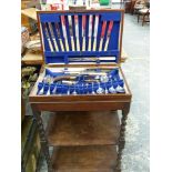 A PART SET PLATED CANTEEN OF CUTLERY ON A FITTED OAK TWO TIER STAND.