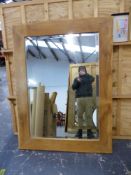 A LARGE OAK RUSTIC FRAMED WALL MIRROR WITH BEVELLED PLATE. 119 X 158cms.
