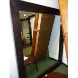 A LARGE OAK FRAMED MIRROR.