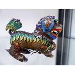 AN EASTERN SILVER AND ENAMELLED FOO DOG.