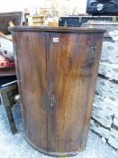 A GEORGE III MAHOGANY BOW FRONT CORNER CABINET.