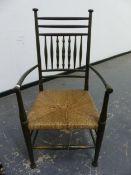 AN ARTS AND CRAFTS RUSH SEAT ARM CHAIR IN THE MANNER OF WILLIAM BIRCH.