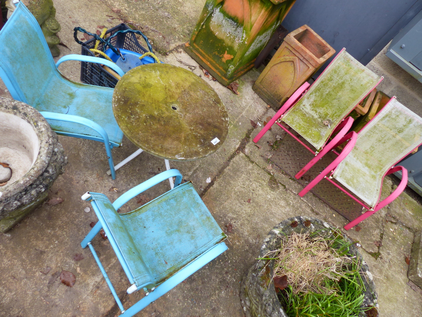 A CHILD'S PATIO SET TABLE AND FOUR CHAIRS TOGETHER WITH A SWING SET AND SLIDE.