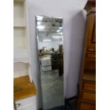 A LARGE BEVEL PLATE UNFRAMED MIRROR.