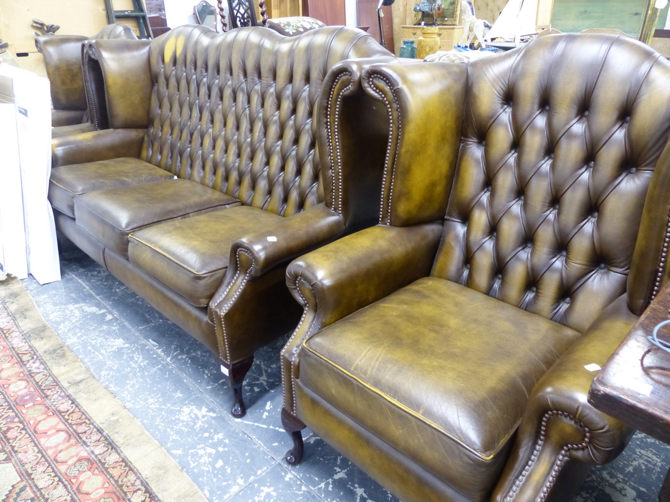 A BUTTON LEATHER UPHOLSTERED WING BACK THREE PIECE SUITE.