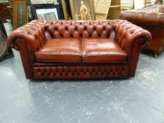 AN ORANGE TAN LEATHER UPHOLSTERED BUTTON BACK CHESTERFIELD SOFABED. W X 164 X D 92 X SEAT HEIGHT 44