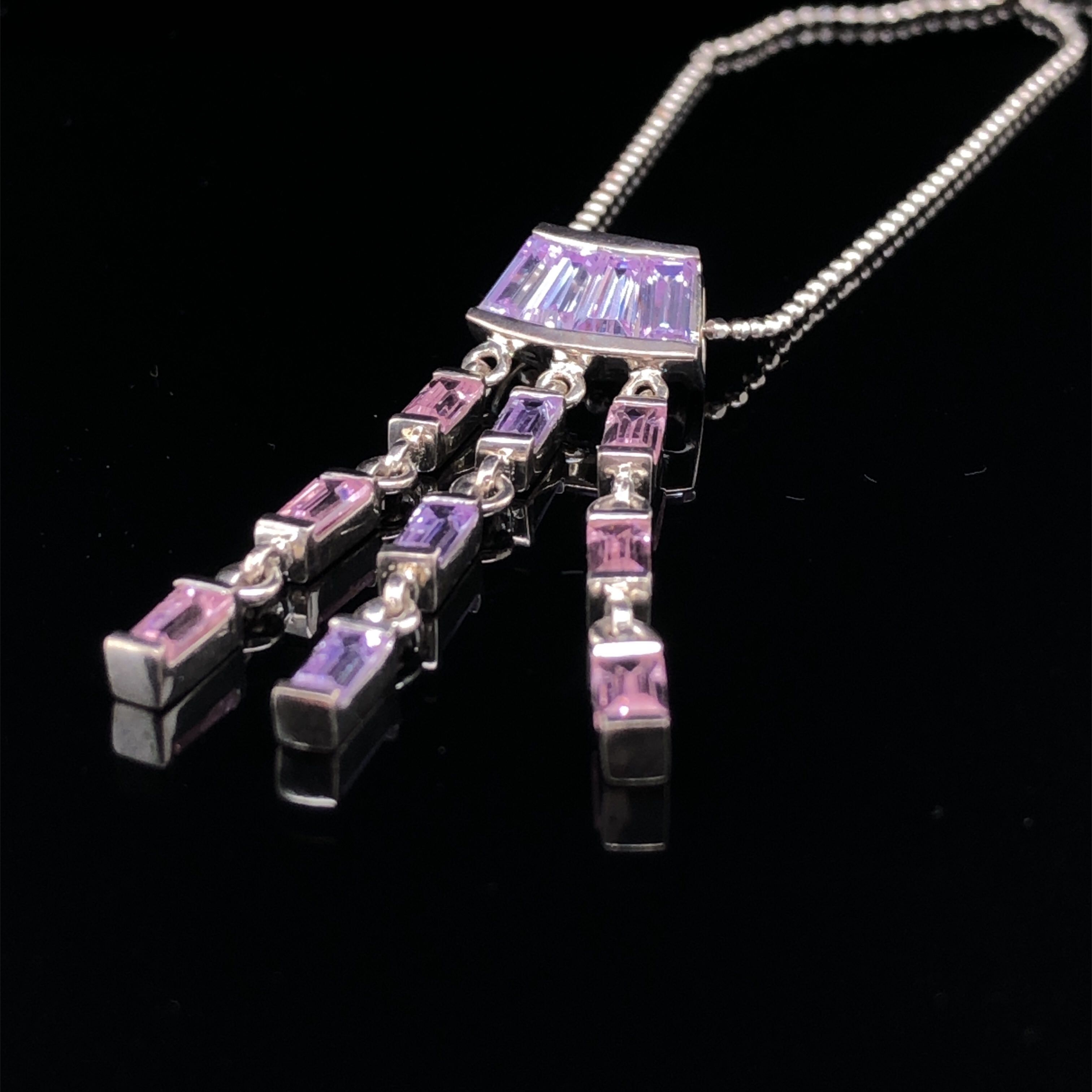 A SILVER AND STONE SET ARTICULATING PENDANT WITH PINK AND PURPLE FACETED STONES SUSPENDED ON A - Image 2 of 2