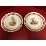 A PAIR OF MEISSEN PLATES, THE ARCADE PIERCED PINK RIMS ENCLOSING COUPLES IN LANDSCAPES, CROSSED