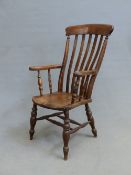 AN ANTIQUE SLAT BACKED ELBOW CHAIR, THE BROAD CURVED TOP RAIL OVER A FIVE BAR BACK, SADDLE SEAT