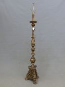 A BAROQUE STYLE SILVERED WOOD STANDARD LAMP CARVED WITH FOLIAGE AND FLUTED ABOVE A TRIANGULAR BASE