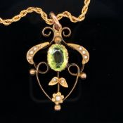 A 9ct GOLD PERIDOT AND SEED PEARL EDWARDIAN ART NOUVEAU PENDANT SUSPENDED ON A 9ct GOLD ROPE