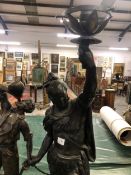 A LARGE SPELTER FIGURAL TABLE LAMP OF AN INDIAN WARRIOR HOLDING ALOFT A FLAME, TOGETHER WITH TWO