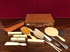 A SWAINE BRIGG LEATHER BRUSH AND COMB FOLDER, TOGETHER WITH PART BRUSH SETS IN IVORY AND IVORINE AND