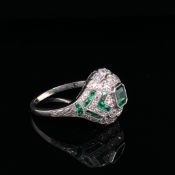 A PLATINUM EMERALD AND DIAMOND ART DECO STYLE COCKTAIL RING. THE BAND SIGNED JOAQ. ESTIMATED