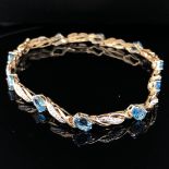 A 9ct GOLD, BLUE TOPAZ AND DIAMOND BRACELET, COMPLETE WITH A FIGURE OF EIGHT SAFETY CLASP. LENGTH
