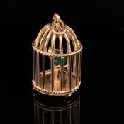 A 9ct GOLD BIRDCAGE PENDANT. INSIDE THE CAGE PERCHES A STONE SET PARROT WITH A GREEN JADE BODY,