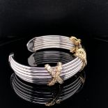 AN 18ct WHITE GOLD AND DIAMOND TORQUE STYLE BANGLE. THE THREE YELLOW GOLD KISSES EACH DIAMOND SET