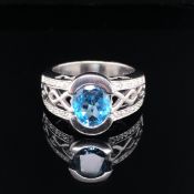 A 9ct WHITE GOLD BLUE TOPAZ AND DIAMOND HALO SET RING. FINGER SIZE R 1/5. WEIGHT 8.8grms.