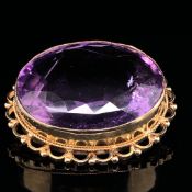 AN AMETHYST SINGLE STONE BROOCH. SET WITH AN OVAL MIXED CUT PURPLE AMETHYST MEASURING APPROX 23.