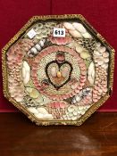 AN OCTAGONAL GILT FRAME OF SHELLS ARRANGED IN COLOURFUL BANDS AROUND THE CENTRAL LOVE HEART. W