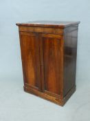 A 19th. C. ROSEWOOD CUPBOARD, THE FIELDED DOORS ENCLOSING TWO SHELVES ABOVE TWO DRAWERS AND THE