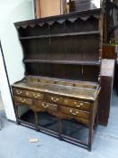 A 19th C. OAK DRESSER WITH THE BACK ENCLOSED BEHIND THREE SHELVES OVER RECESSED DRAWERS, THE BASE