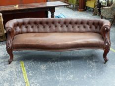 A VICTORIAN MAHOGANY SETTEE, THE BACK BUTTONED IN IMITATION LEATHER, THE FRONTS OF THE ARMS CARVED