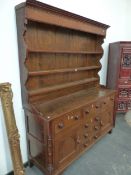 A 19th C. OAK DRESSER, THE ENCLOSED THREE SHELF BACK RECESSED ABOVE THE BASE WITH FOUR DRAWERS