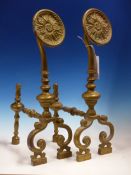 A PAIR OF BRASS FIRE DOGS, EACH FRONT WITH FLOWER HEAD ROUNDEL RAISED ON BALUSTER COLUMN ABOVE TWO