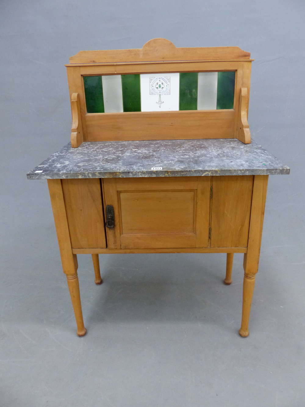 AN EDWARDIAN GREY MARBLE TOPPED PINE WASHSTAND WITH A TILED BACK ABOVE A DOOR TO THE FRONT, THE