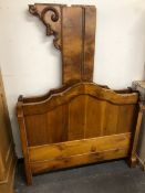 A WALNUT FRENCH SINGLE BED, THE SERPENTINE TOPPED HEAD AND FOOT BOARDS JOINED BY SCROLL BRACKETS