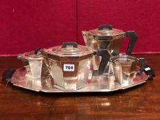 AN ART DECO ALPACCA FOUR PIECE TEA SET ON AN EBONY HANDLED TRAY, VARIOUSLY STAMPED MARKS TO