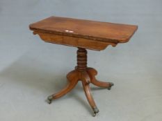 A MAHOGANY CARVED REGENCY CARD TABLE. BAIZE INSET SWIVEL TOP, SABRE LEGS, BRASS PAW CASTORS. W. (