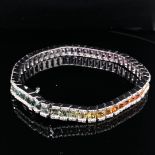 AN 18ct WHITE GOLD DIAMOND AND MULTICOLOURED RAINBOW SAPPHIRE LINE BRACELET. THE ARRAY OF