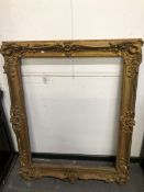 A LARGE ANTIQUE SWEPT GILT FRAME, REBATE 106 x 82.5.cms TOGETHER WITH ANOTHER WITH STRAP WORK